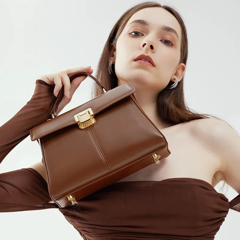 Women's black genuine leather shoulder bag with vachette clasp closure showing horizontal square design