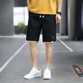 Man wearing loose-fit green casual beach shorts in a South Korea style, showing the straight cut and relaxed fit.
