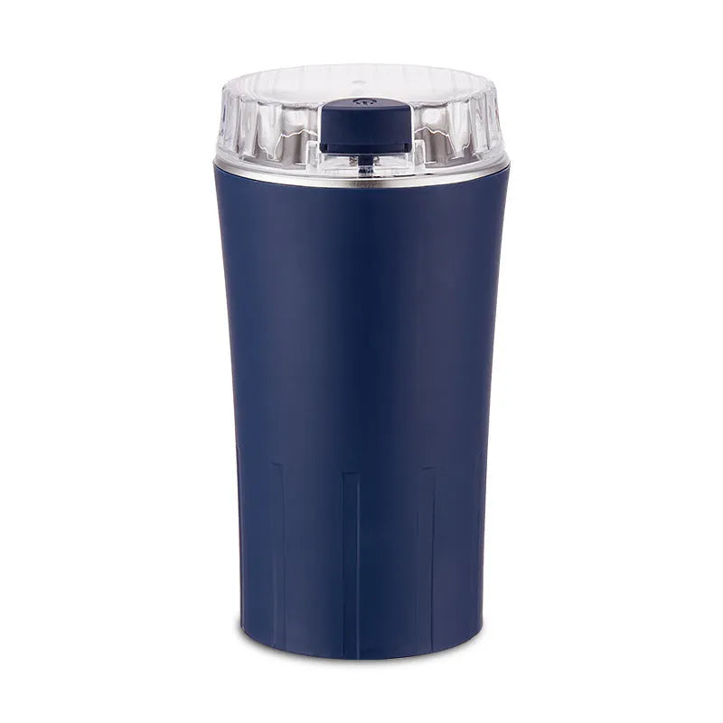 Blue mini electric grain and spice grinder with stainless steel blade on a kitchen worktop