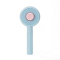 Blue pet grooming brush with metal angled needles and a self-cleaning button on the plastic handle.