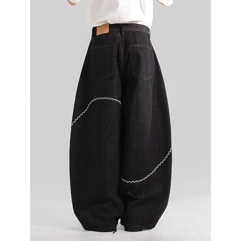 Black straight-leg denim trousers on a hanger, showing mid waist and zip placket detail.