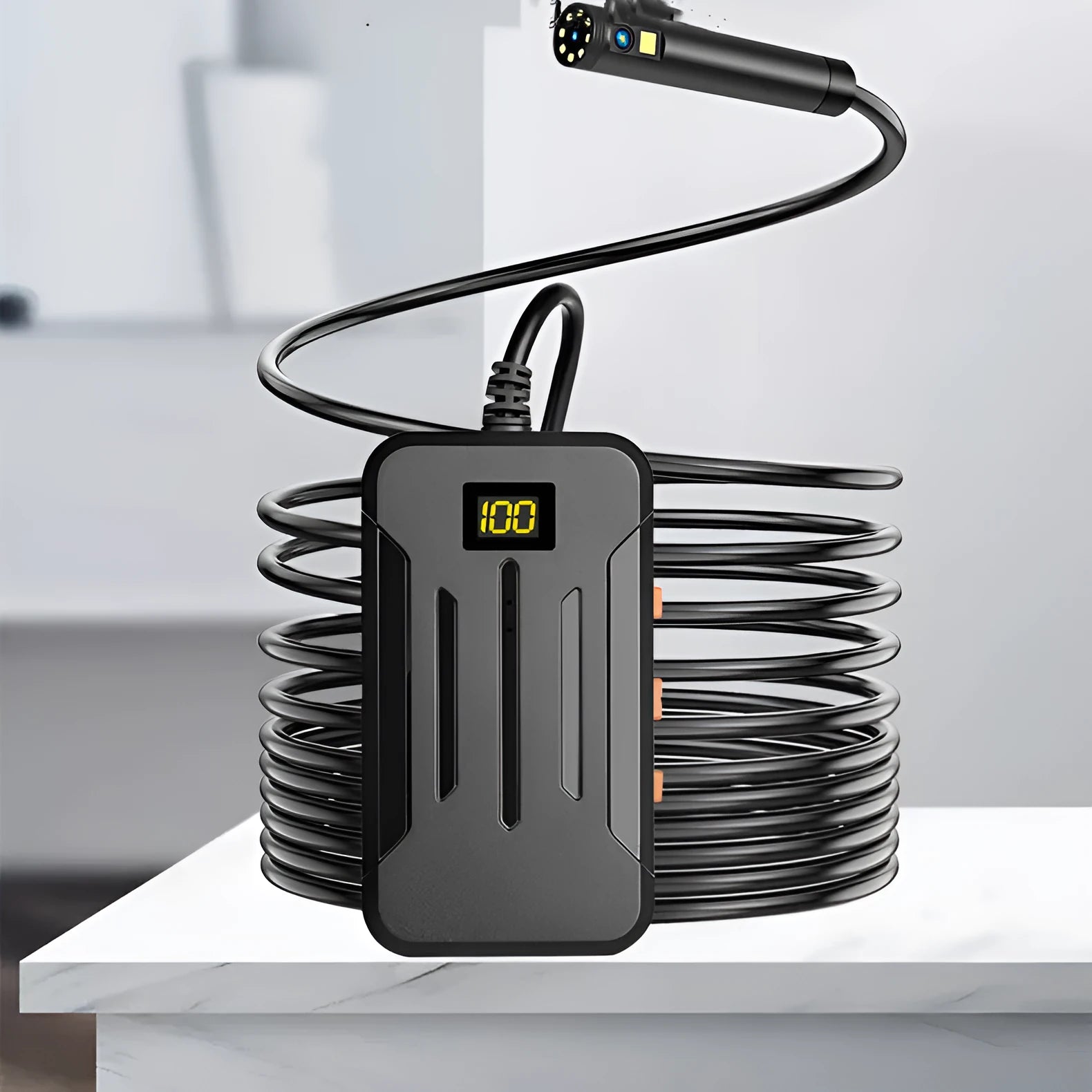 Wireless endoscope with dual-lens camera, magnet, and hook accessories on a table