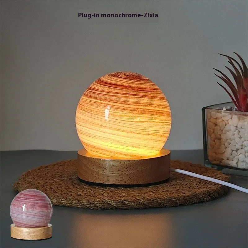 Compact modern planet USB night light on its base with dimmable three-colour lighting.