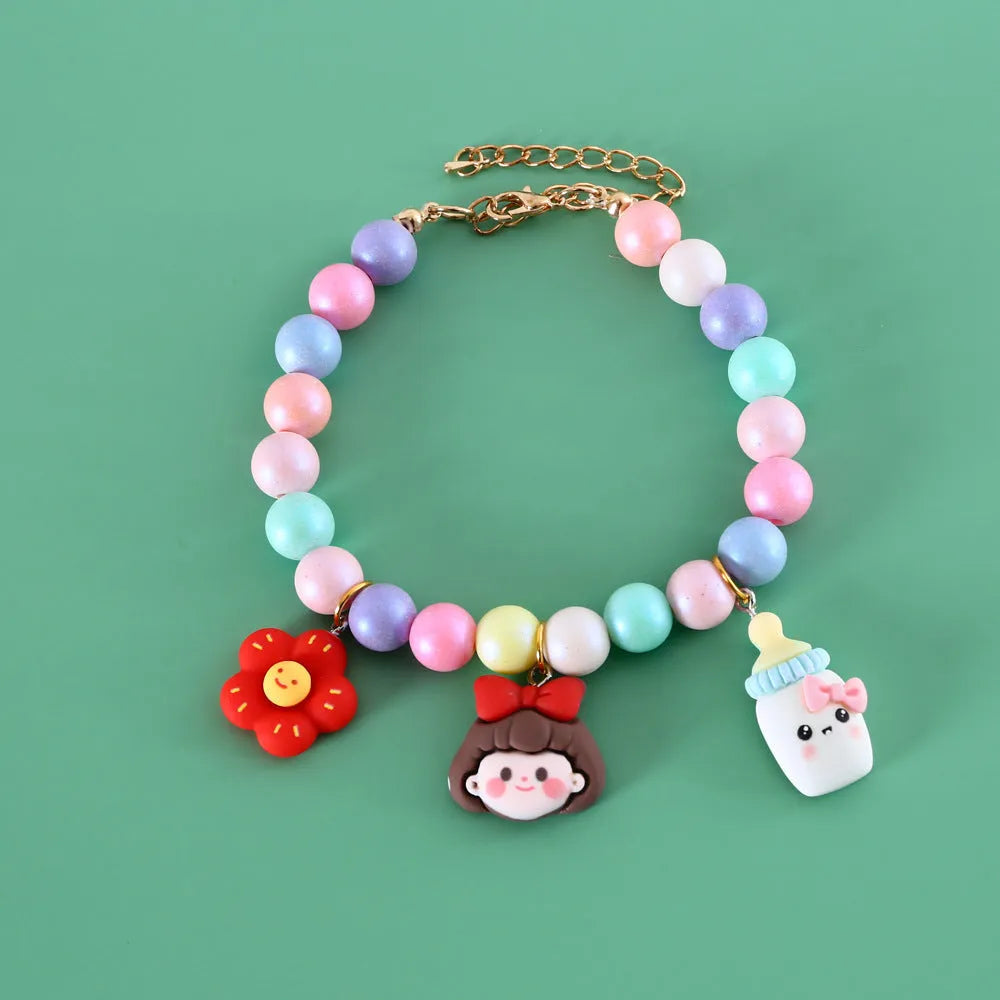 Macaron-coloured resin pet collar and bracelet set for birthday photoshoots on a neutral background.