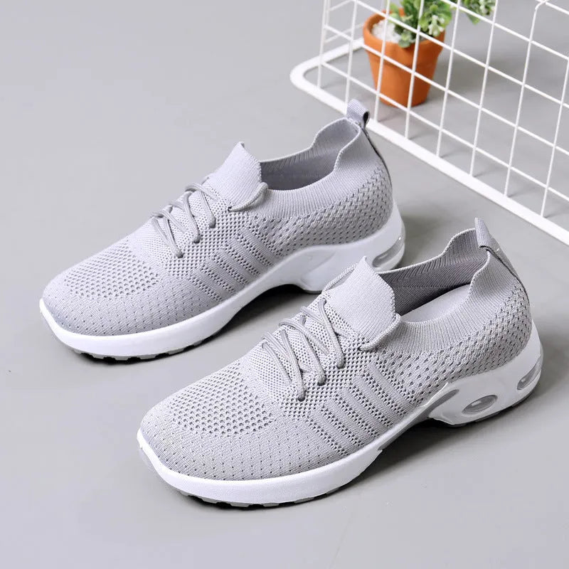 Women's black mesh casual sneakers with round toe and white lace-up front on a grey PVC sole.