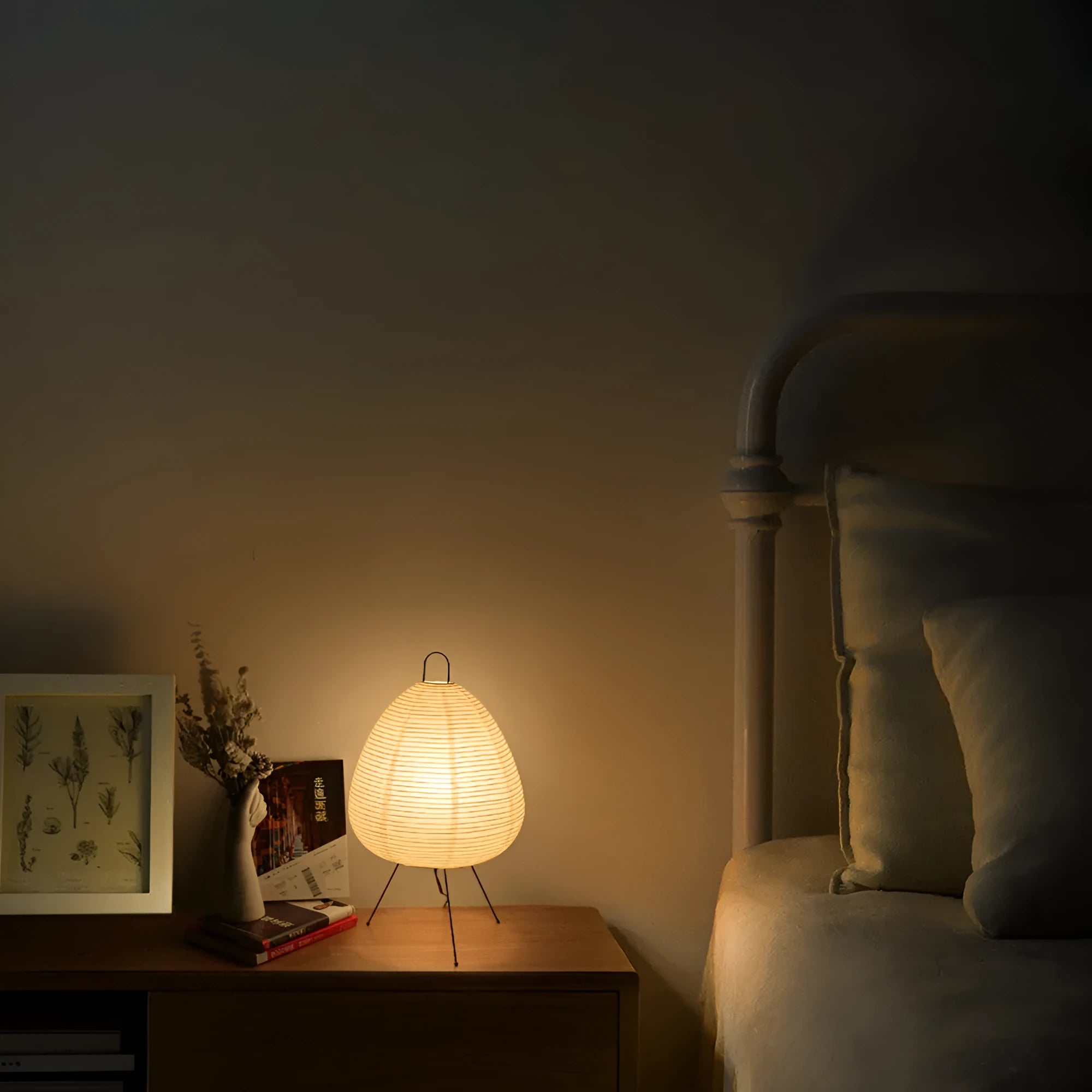 Japanese style handmade rice paper lantern table lamp with aluminium base on a wooden table.