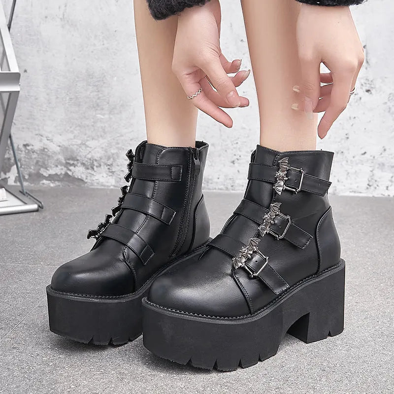 Black women's punk style ankle boots with bat buckle and side zip.