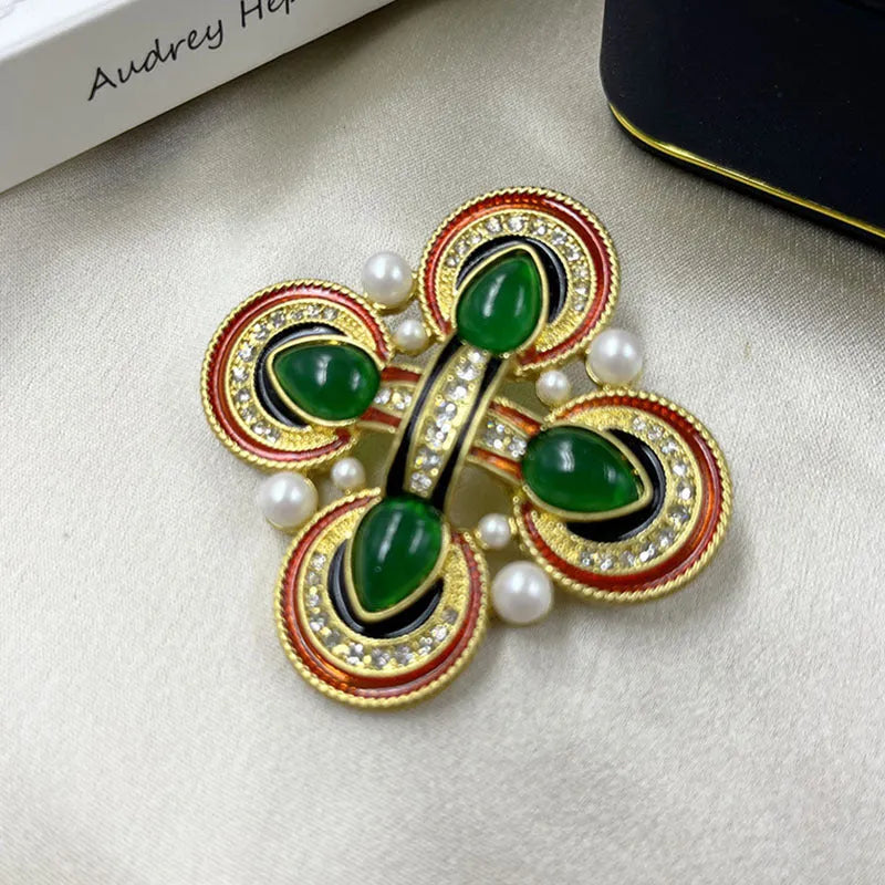 A vintage-style zinc alloy brooch with a baroque cross design and crystal accents.