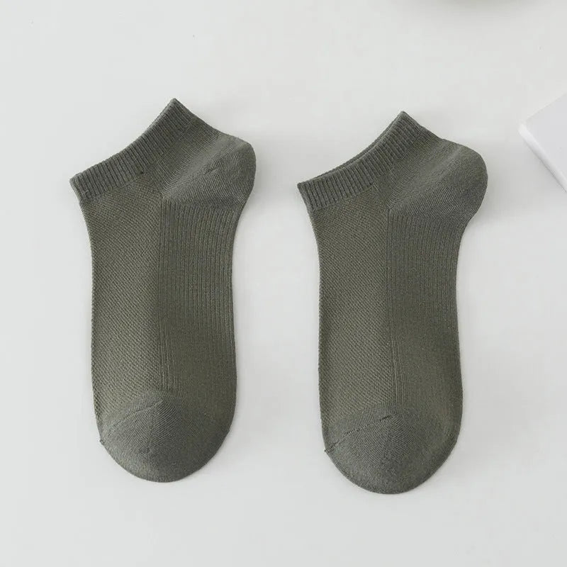 Solid colour low-cut polyester boat socks for men on a neutral background.