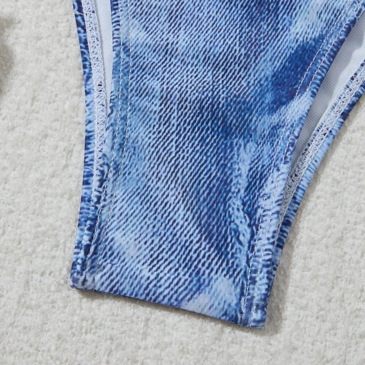 Women's denim blue printed bikini swimsuit with strap design on a hanger