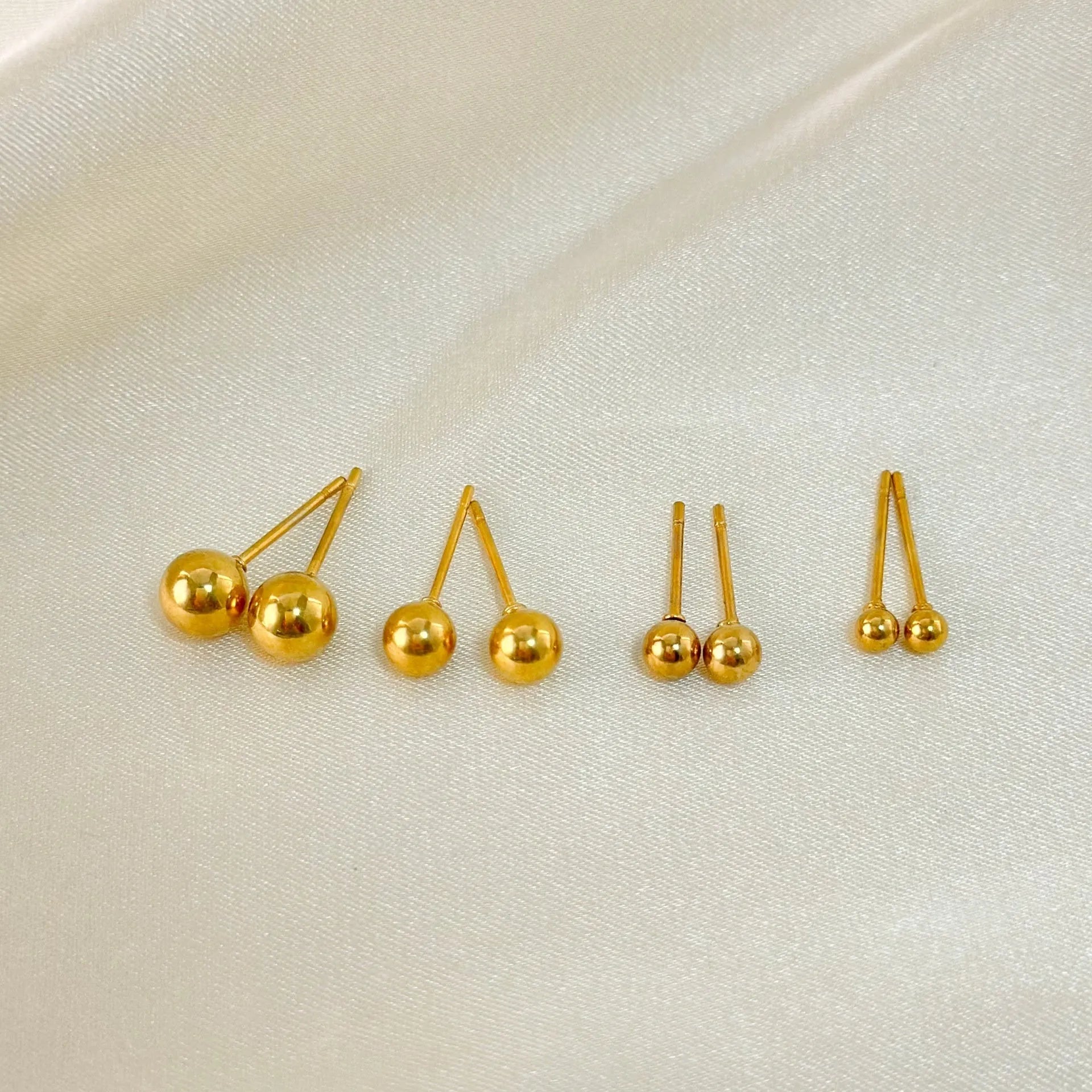 Minimalist stainless steel ball stud earrings in gold and silver tones, showing 3mm 4mm 5mm 6mm size difference.