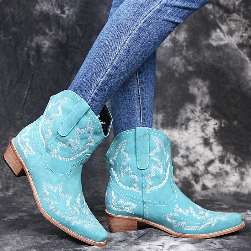 Blue women's cowboy boots with floral embroidery, a wedge heel, and a pointed toe.