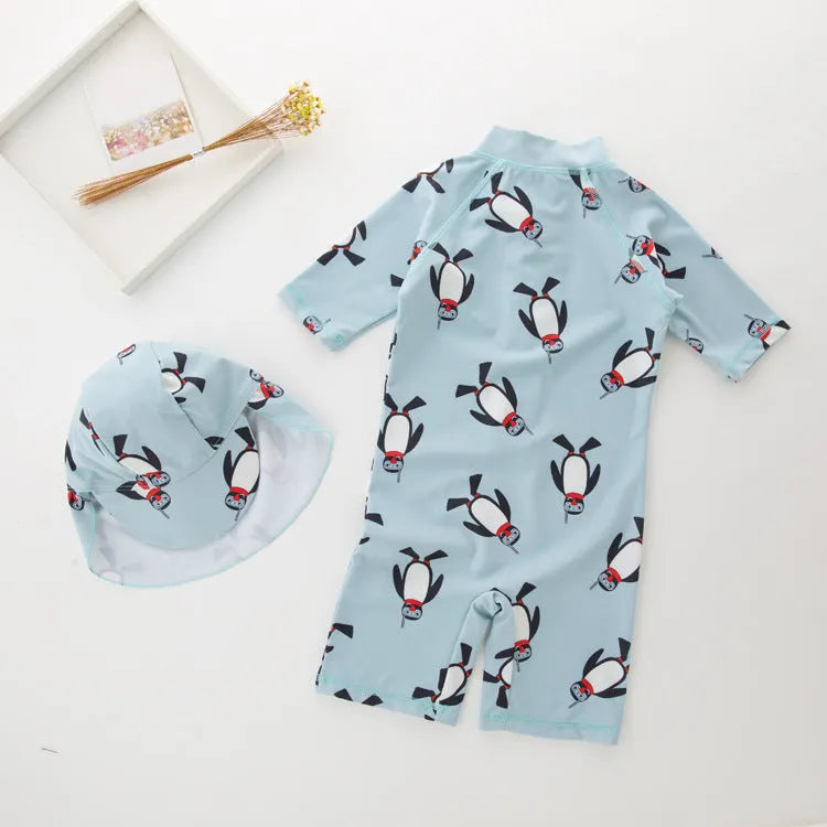 Boys' penguin print long sleeve swim top and matching swimming cap set on a hanger.