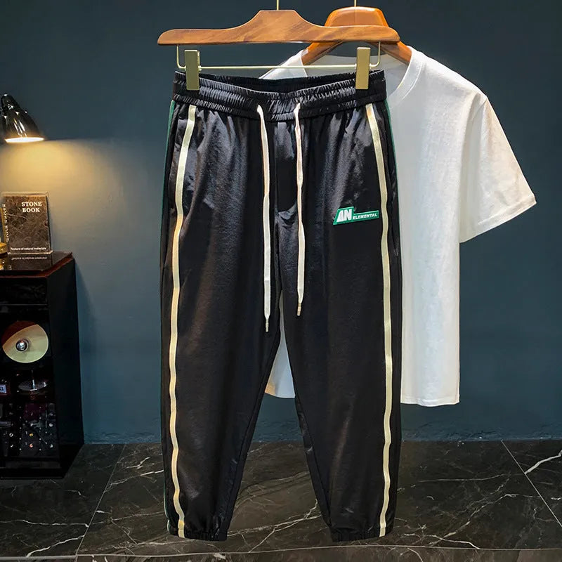 A man wearing grey cotton harem pants with a relaxed fit and elasticated mid-waist.