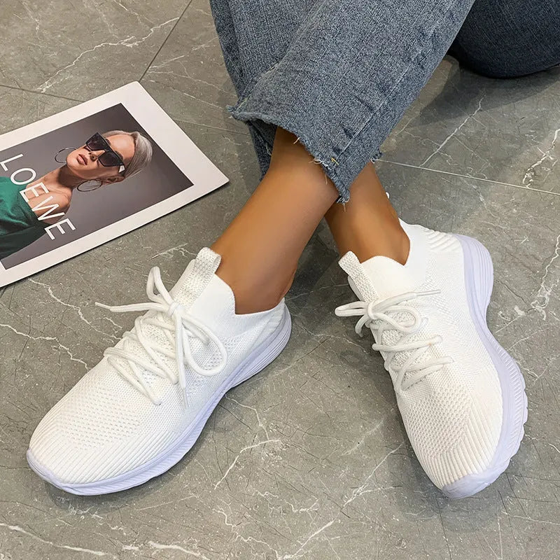 Women's low-top running shoes with mesh lining and Flyknit upper in creamy white, grey, or orange colours
