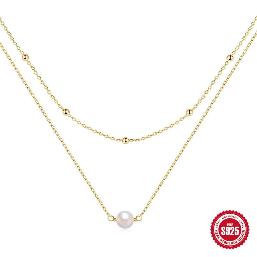 S925 sterling silver double layer necklace with twin pearls in gold or white gold finish featuring geometric pendant and ball bead chain.