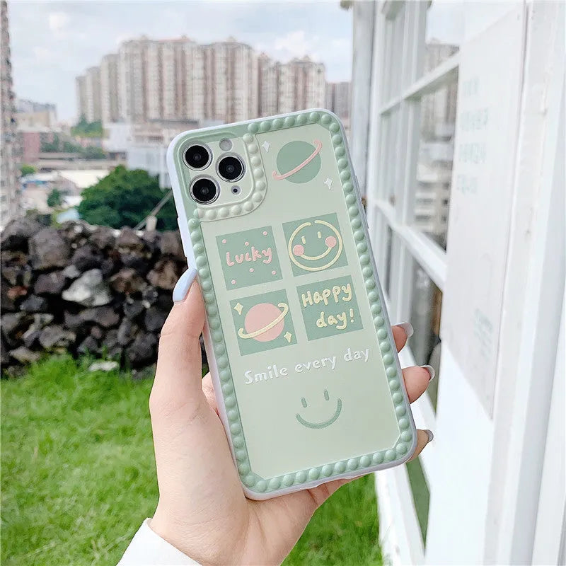 Green TPU iPhone case with polka dot frame and smiley face design on the back.