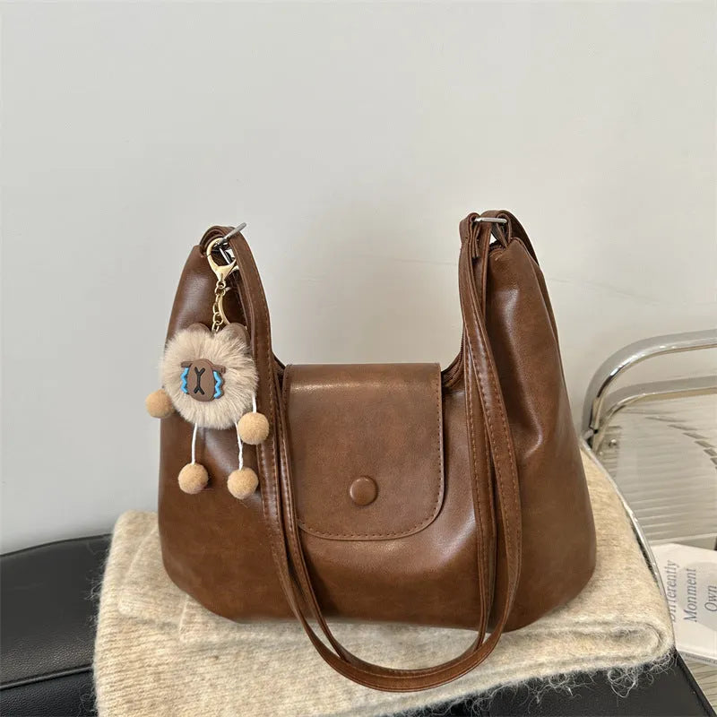 Women's textured PU leather shoulder bag with single strap and mobile phone compartment in black colour