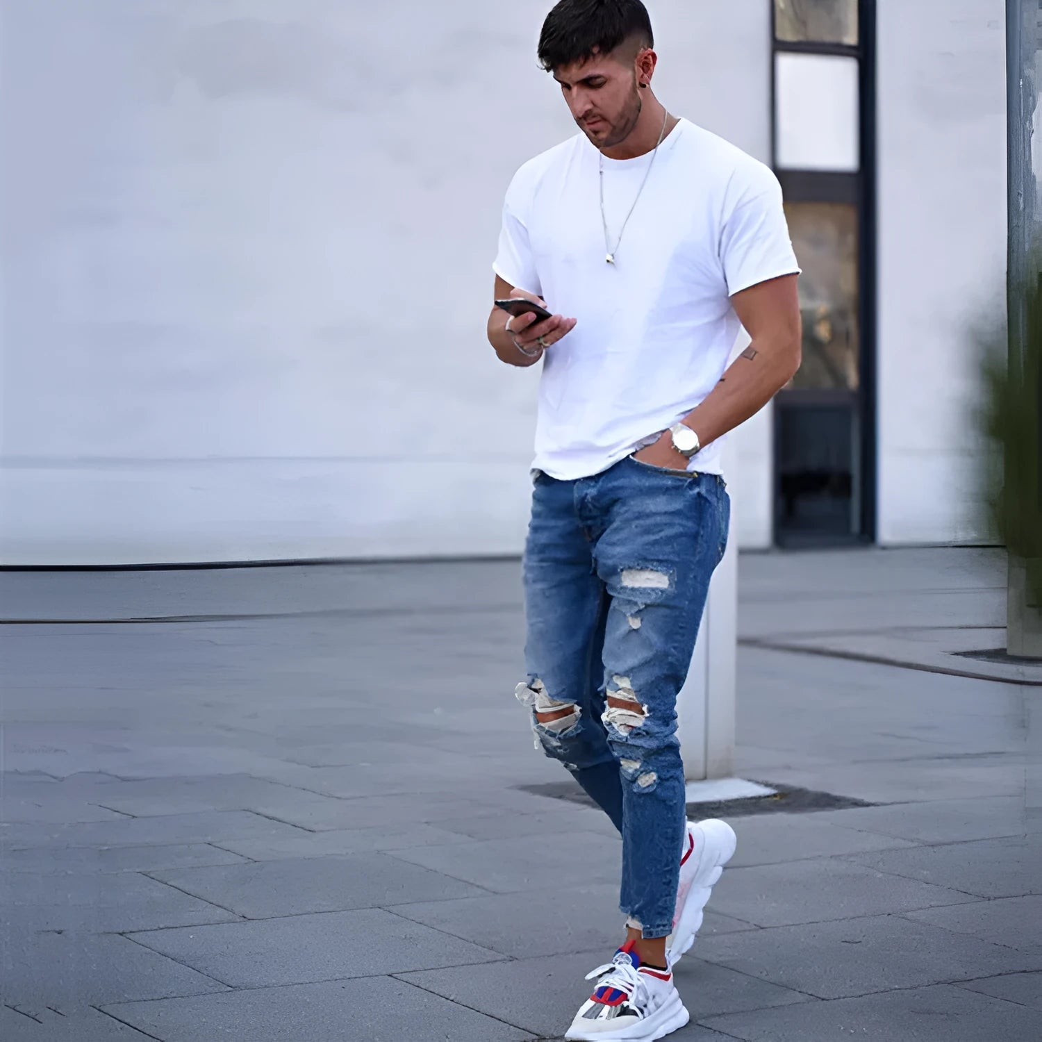 Men's deep blue cotton jeans featuring distressed hole details on the legs.