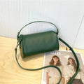 Vegetable-tanned leather crossbody phone bag with cylindrical shape and visible sewing thread detailing