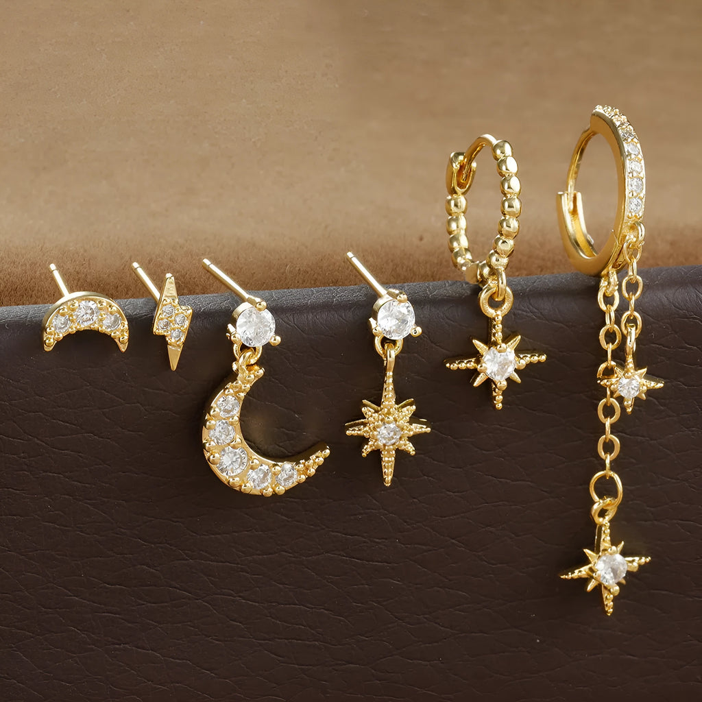 Six pairs of gold chain tassel earrings with zircon studs displayed together