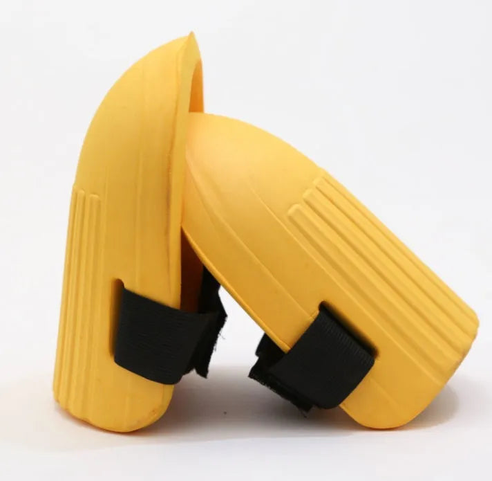 A pair of thick EVA foam kneepads in army green colour on a garden soil background.