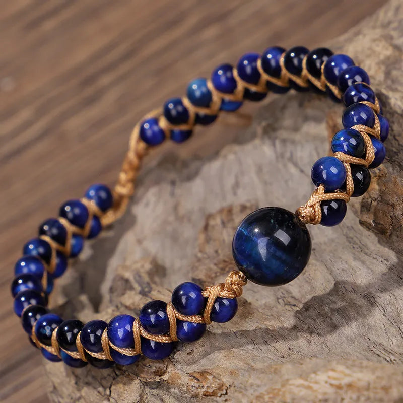 Handmade woven geometric bracelet with blue tigereye stone beads and adjustable pull closure.