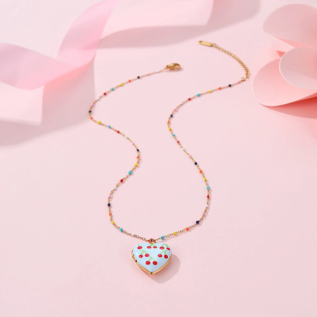 Women's stainless steel necklace with 18K gold plating showing heart pendant with fruit designs