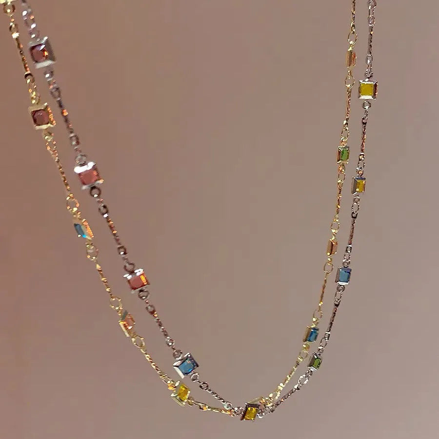 Fine gold-tone geometric necklace with a square clear crystal pendant on a clavicle-length chain.