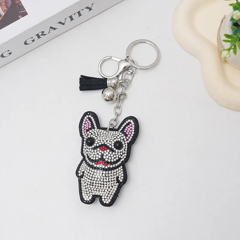 Close-up of a cartoon dog rhinestone keychain charm in alloy, showing sparkling details on a grey background.