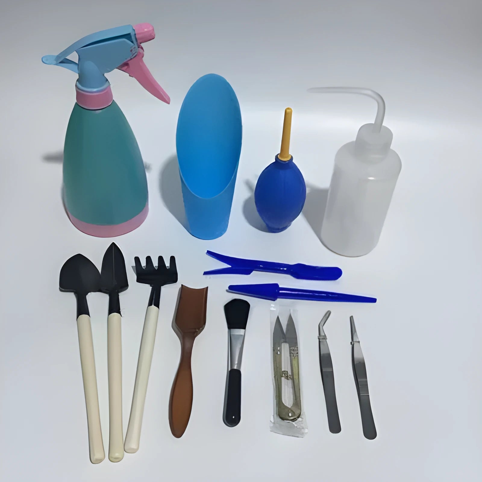Succulent gardening tool set showing watering can, tweezers, mini shovel and brush for small plant care