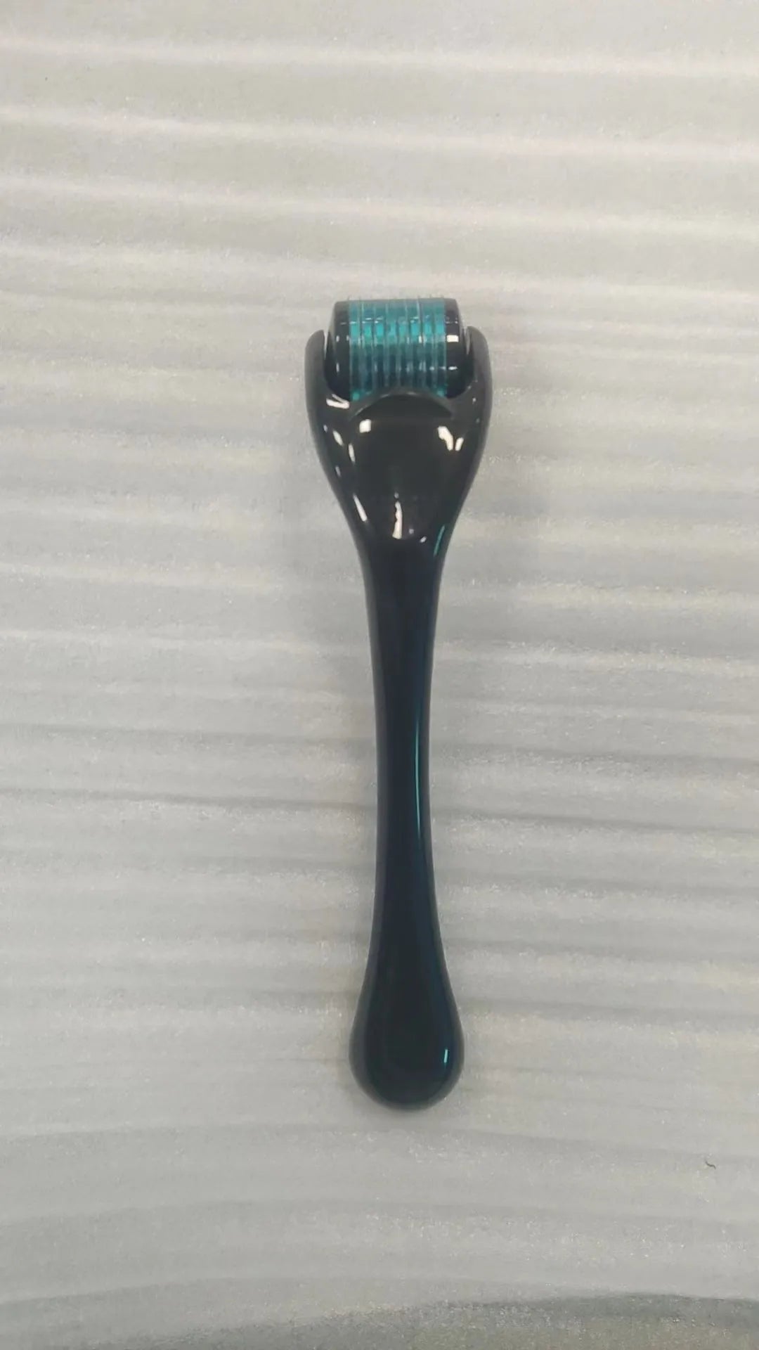 Black handle micro needle roller with purple wheel showing 540 stainless steel needles for dermaplaning