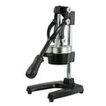 Black cast iron manual juicer with stainless steel strainer on a kitchen counter