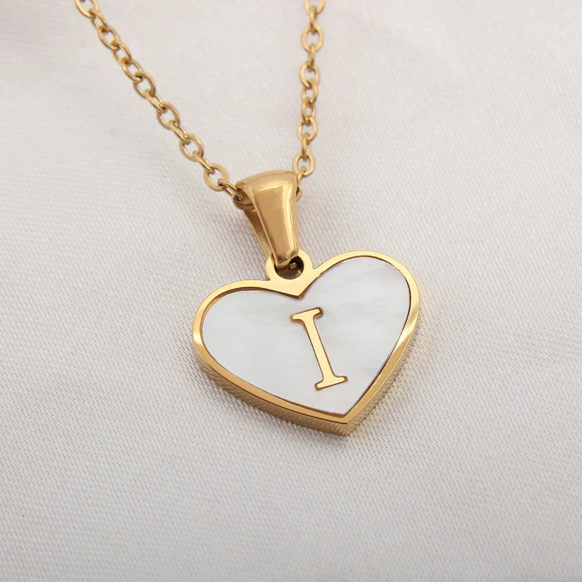 Gold plated heart-shaped personalised necklace with white shell charm on an adjustable chain.