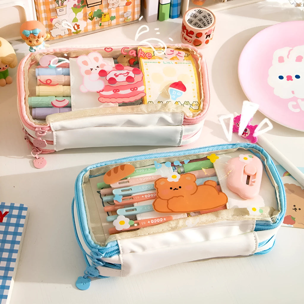 Transparent pink heart-shaped pen case with a cartoon cake and rabbit design, shown open.