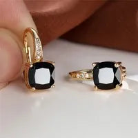 Square geometric ear hook earrings with zircon stones in an electroplated copper setting.