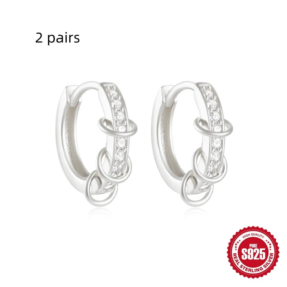 Sterling silver geometric stud earrings with a small round shape and classic diamond detail on a white background.