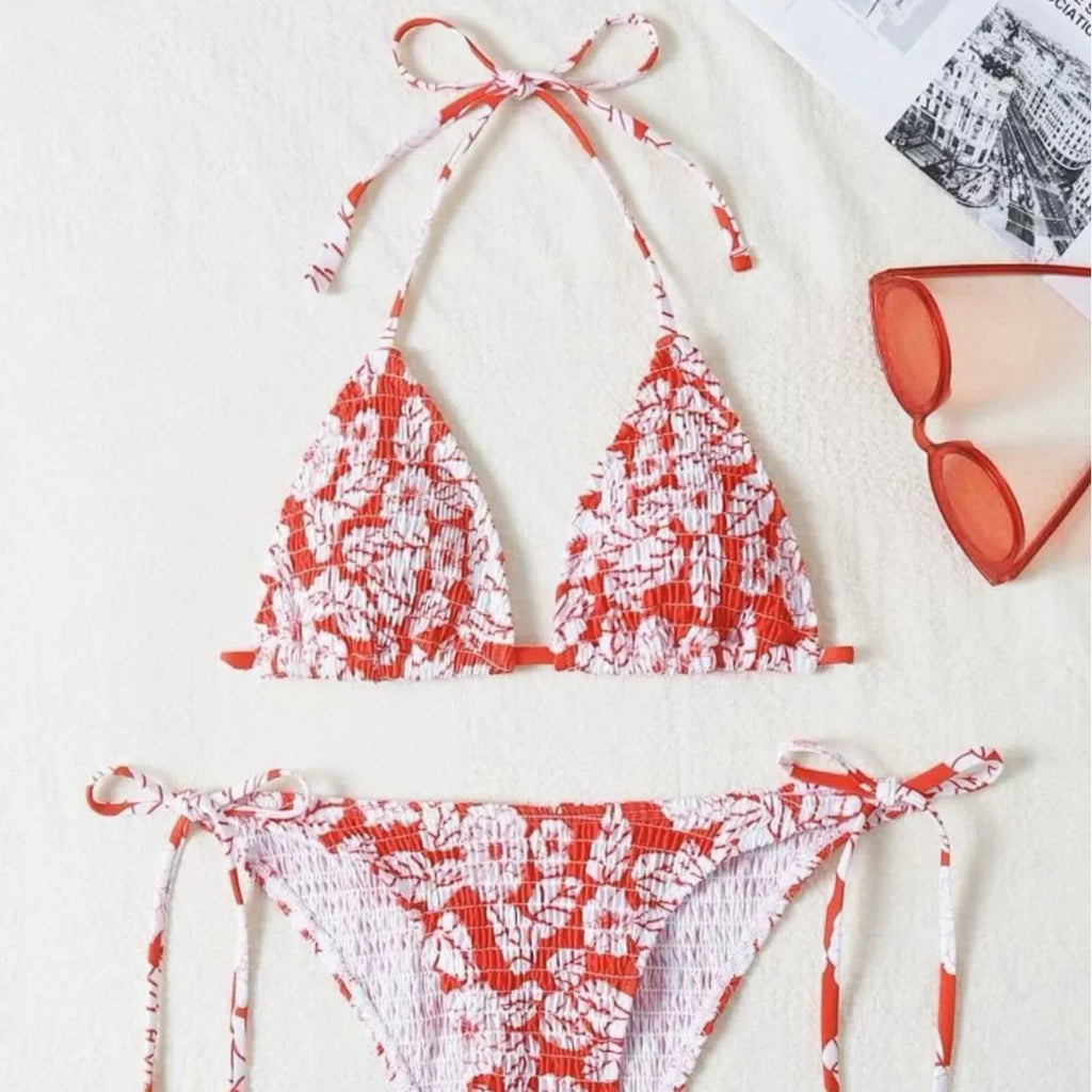Women's pink floral halter neck swimsuit top and briefs set on a neutral background