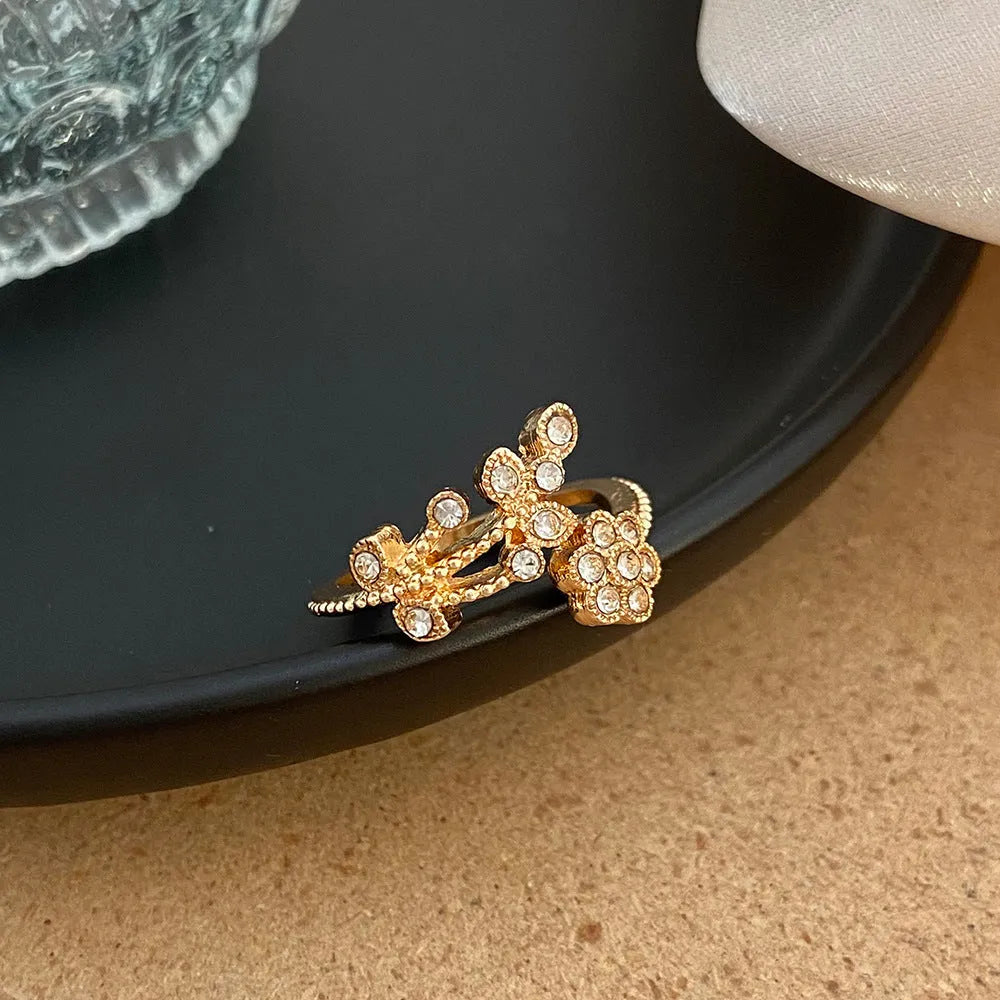 Gold and white copper open ring with diamond-finished flower and leaf design for women.
