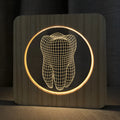 Wood-coloured tooth-shaped acrylic night lamp on a table with USB cable