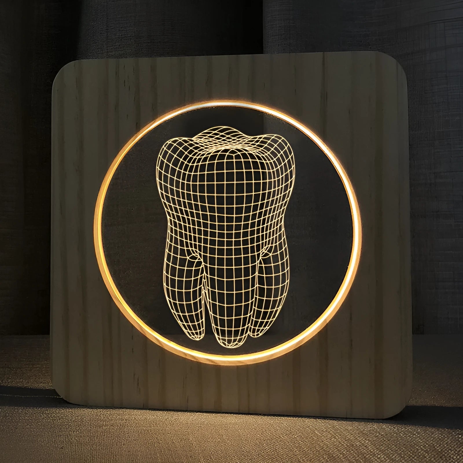 Wood-coloured tooth-shaped acrylic night lamp on a table with USB cable