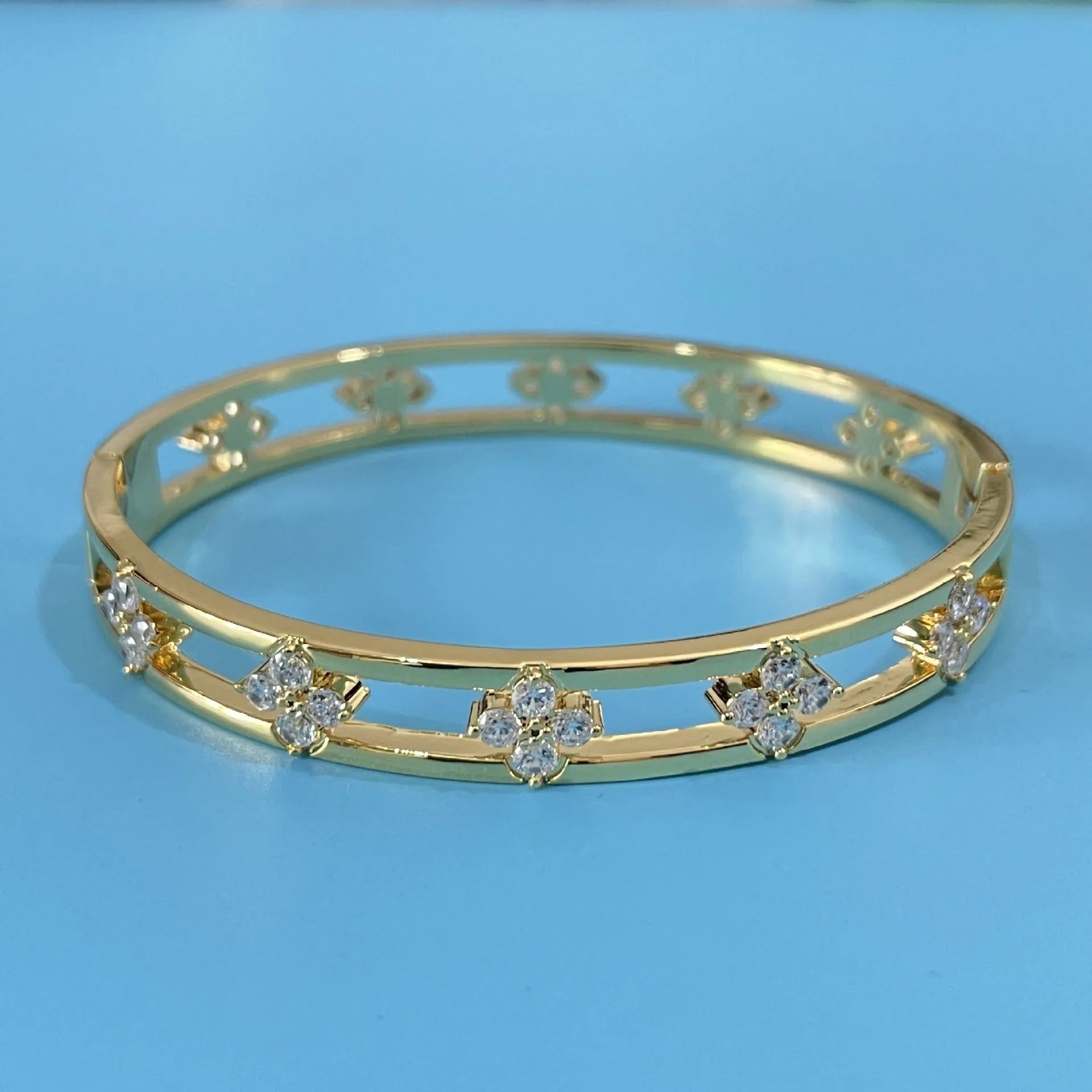 Women's hollow bracelet with four-leaf clover pattern and zircon stones in gold or silver finish