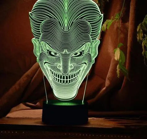 3D LED table lamp showing seven colour options with remote control and USB cable on wooden surface