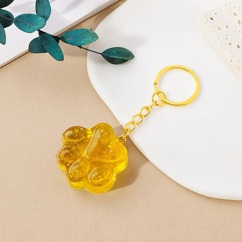 Natural crystal cat's paw keychain pendant in various gemstone colours including pink, red, blue, and green