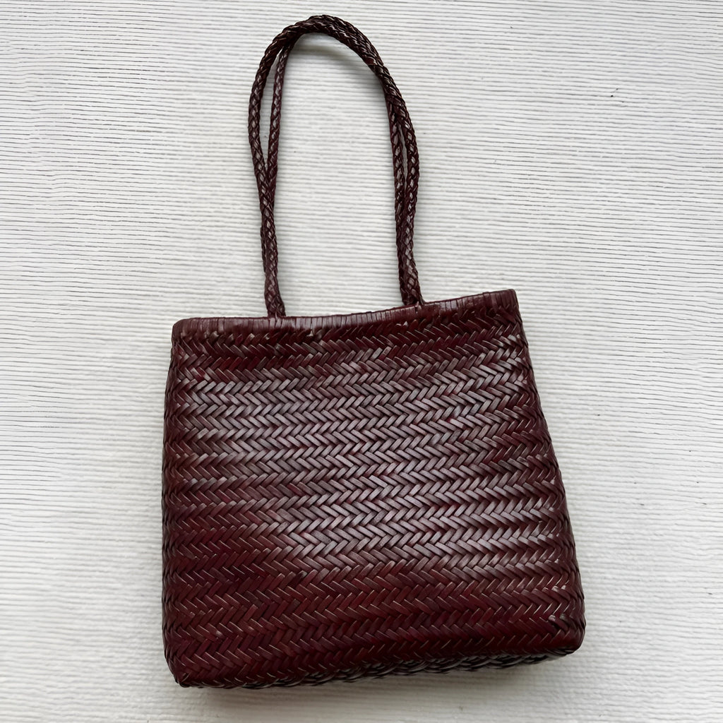 Brown handmade cowhide leather shoulder bag with woven tote design and three-dimensional pocket