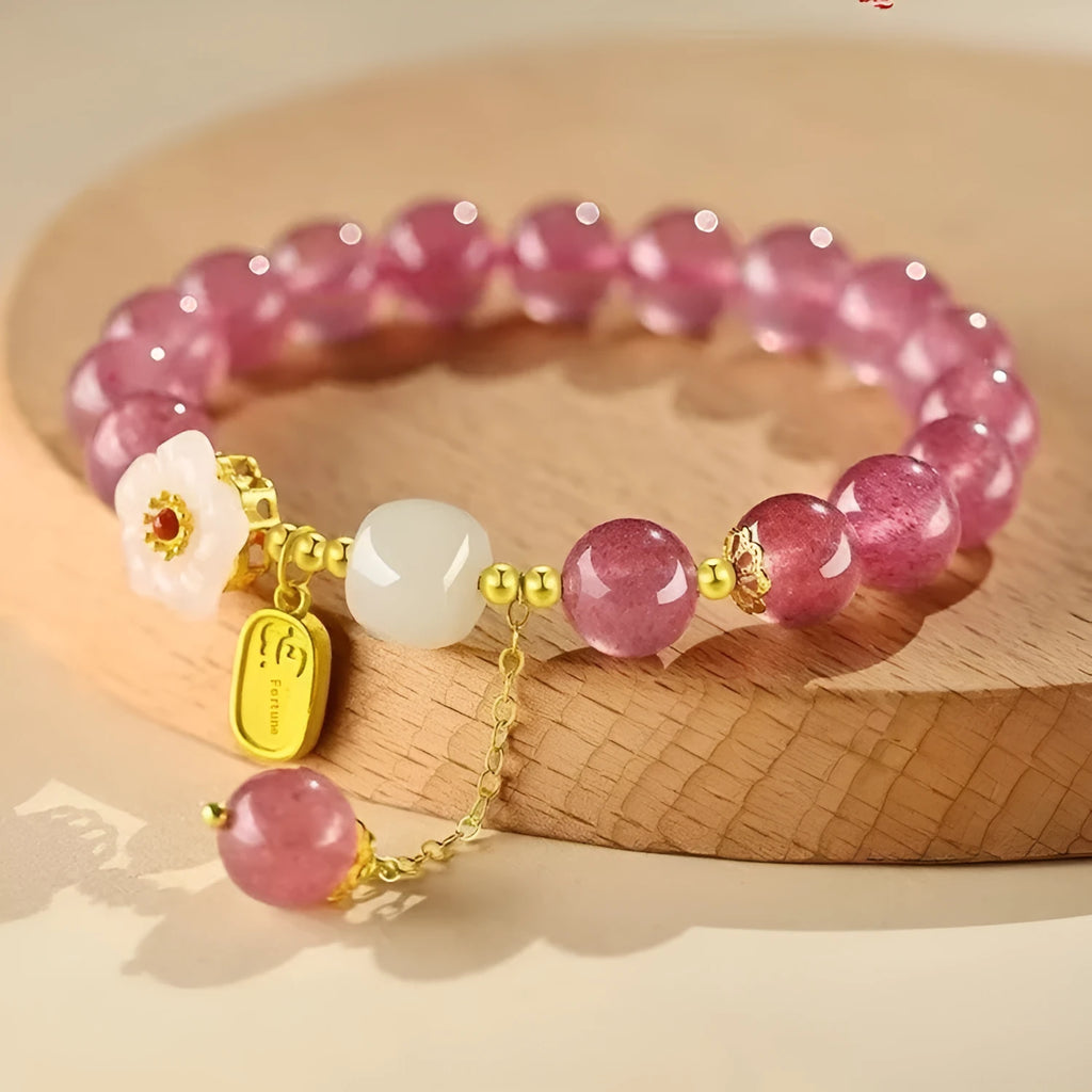 Handcrafted strawberry quartz crystal bracelet with peach blossom design on wrist