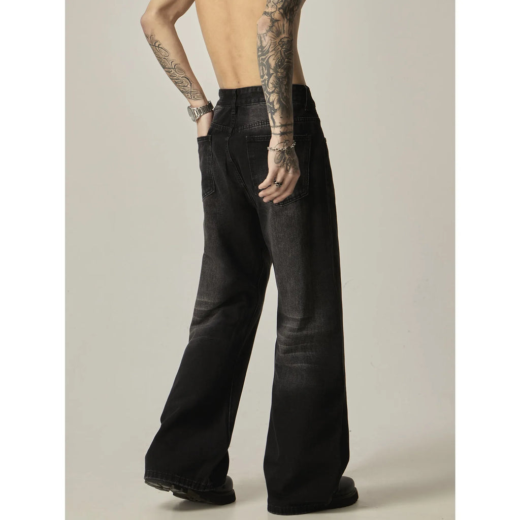 Man wearing black loose-fit straight-leg retro jeans in a casual setting.