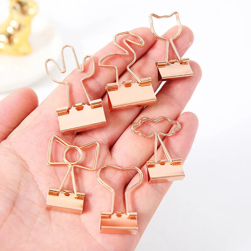 Gold long tail metal clip with decorative charm shape for document organisation