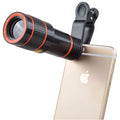 12X magnification phone telescope lens with adjustable mounting clip and cleaning cloth on a table.