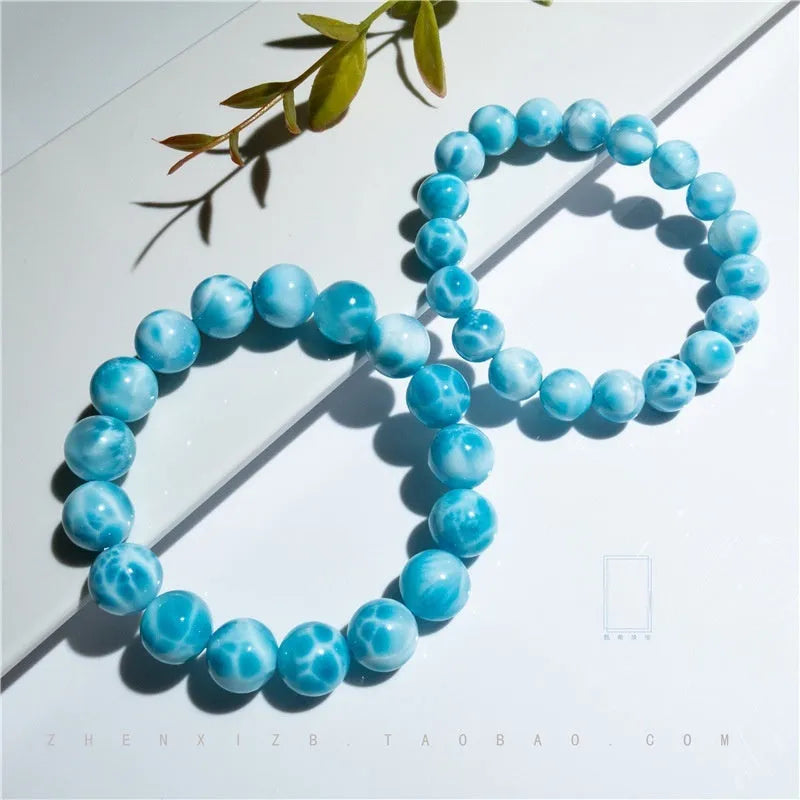 Blue natural Bodhi seed and crystal sea-pattern stone bracelet with a single pearl accent on a wrist.